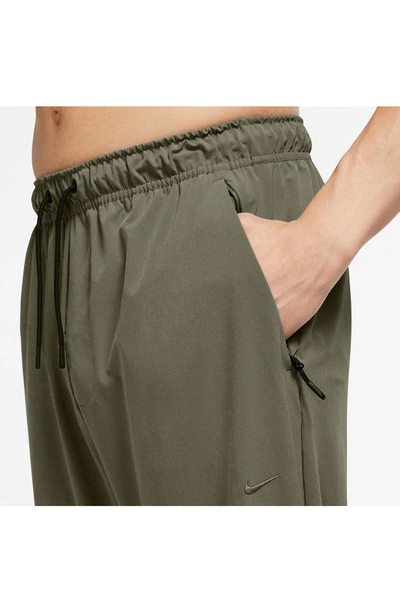 Shop Nike Dri-fit Unlimited Drawstring Pants In Medium Olive/ Black