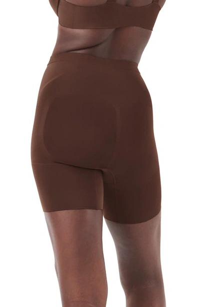 Shop Spanx Oncore Mid Thigh Shorts In Chestnut Brown