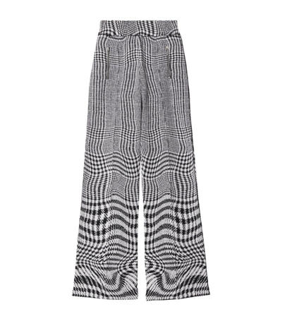 Shop Burberry Warped Houndstooth Print Trousers In Black