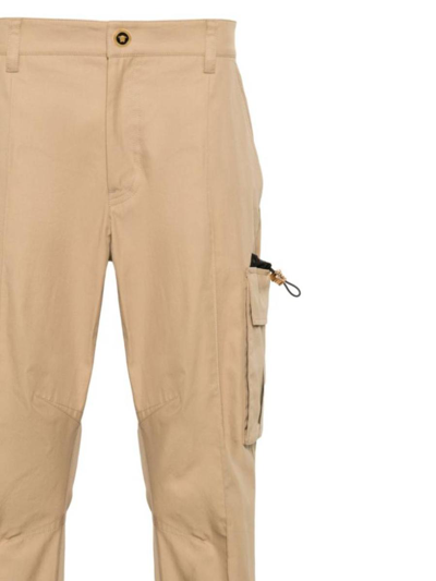 Shop Versace Trousers In Sand