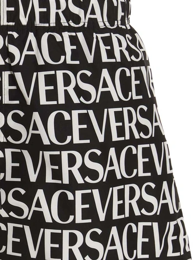 Shop Versace 'logomania' Swimming Trunks In White/black