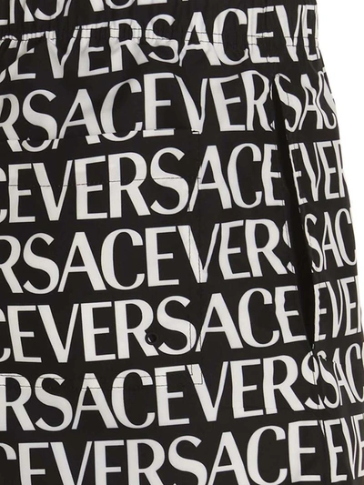 Shop Versace 'logomania' Swimming Trunks In White/black