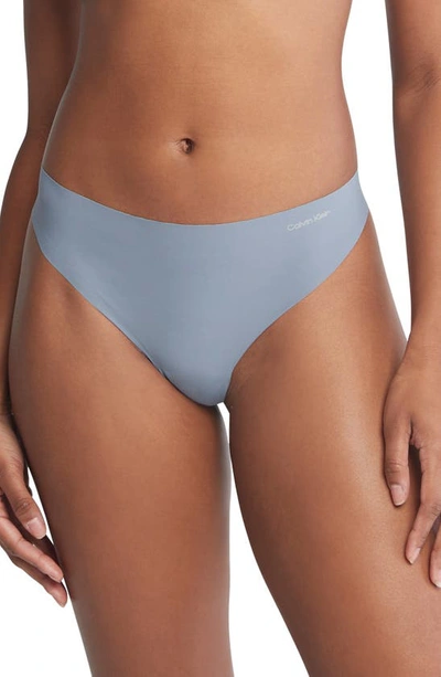 Shop Calvin Klein Invisibles 3-pack Thongs In Blue/ Pink/ Flintstone