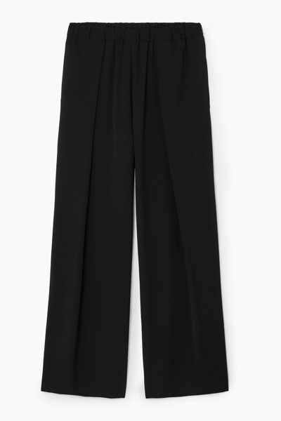 Shop Cos Pleated Elasticated Wide-leg Trousers In Black