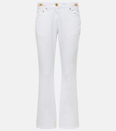 Shop Versace Embellished Low-rise Flared Jeans In White