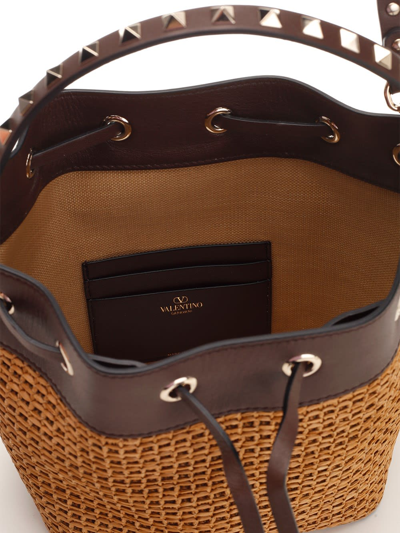 Shop Valentino Rockstud Bucket Bag In Raffia In Brown