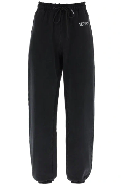 Shop Versace Distressed Jogger Pants With Logo Embroidery Women In Black