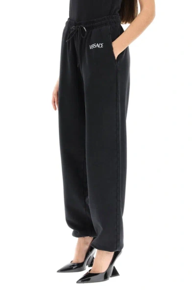 Shop Versace Distressed Jogger Pants With Logo Embroidery Women In Black