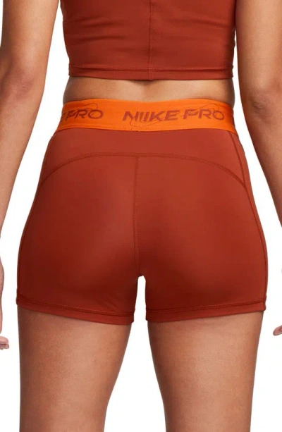 Shop Nike Pro Mid Rise Graphic Training Shorts In Rugged Orange/ Safety Orange