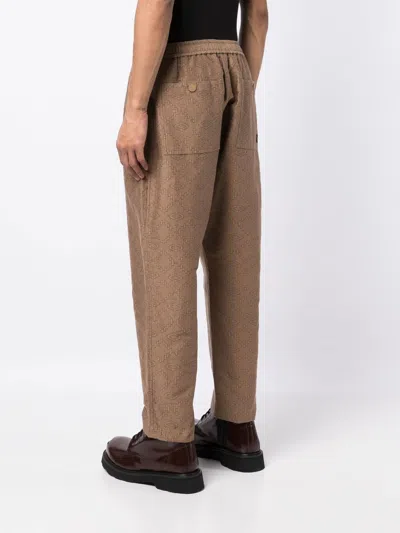 Shop White Mountaineering Geometric-print Tapered Trousers
