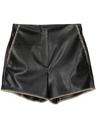 Shop Nanushka Elza Faux Leather Shorts With Rafia Trim In Black
