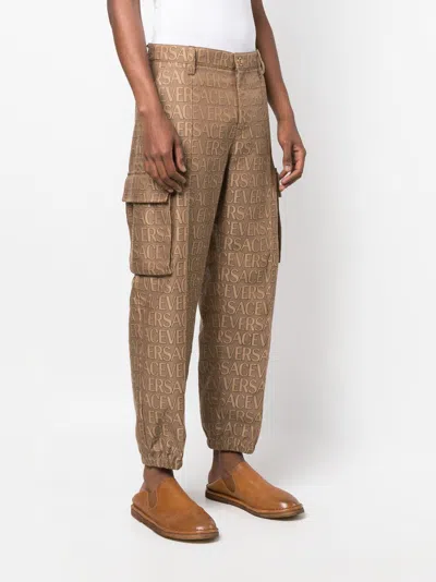 Shop Versace Men's  All-over Motif Cargo Trousers For Fw23 In Brown