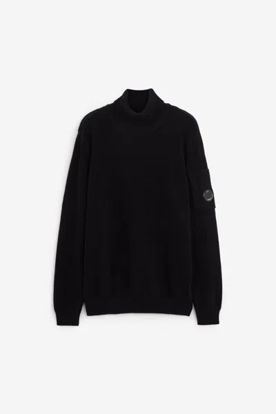 C.p. Company Ribbed Knit Roll Neck Sweater With Signature Lens Detail And Zip Pocket In Black
