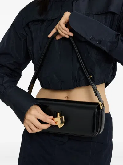 Patou Shoulder Bag With Structured Silhouette And Adjustable Strap In Schwarz
