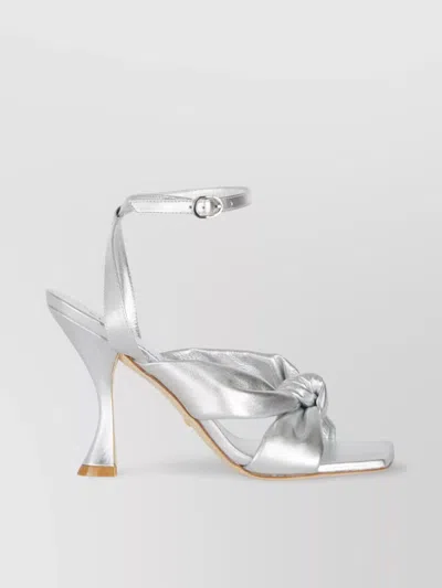 Stuart Weitzman Heeled Sandals With Knot Detail And Metallic Finish In Grey