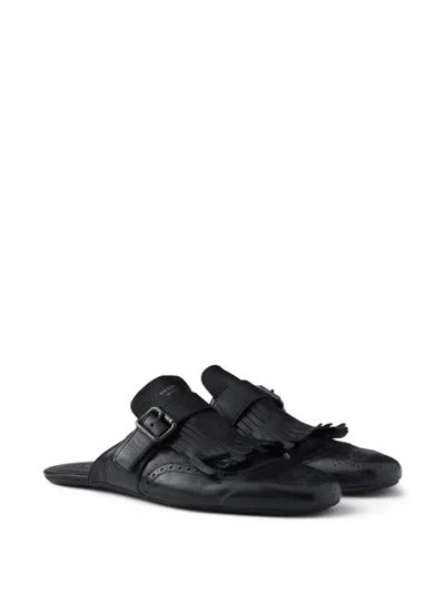 Prada Shuffle Antiqued Leather Mules With Buckled Strap And Fringe In Black