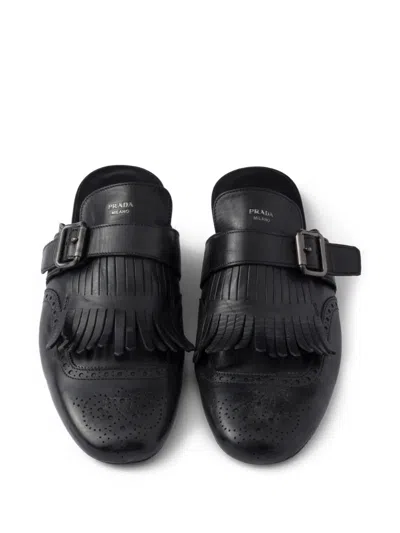 Prada Shuffle Antiqued Leather Mules With Buckled Strap And Fringe In Black