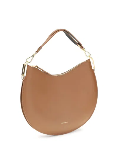 Coccinelle Large Sunup Half-moon Calfskin Shoulder Bag In Sand