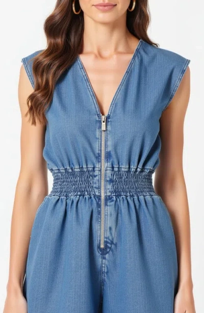 Modenaire Denim Romper With Cap Sleeves Smocked Waist And Front Zip Closure In Blue