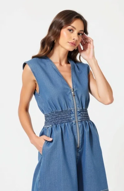 Modenaire Denim Romper With Cap Sleeves Smocked Waist And Front Zip Closure In Blue