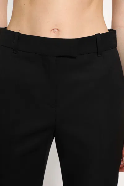 Alexander Mcqueen Tailored Wool Trousers Featuring Flared Hem In Black