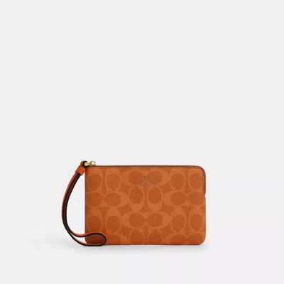 Coach Corner Zip Wristlet In Signature Canvas In Orange