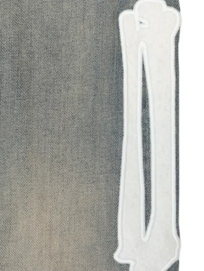 Amiri Bone Appliqué Jeans In Blue