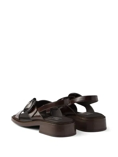 Prada Brushed Leather Crisscross Band Sandals With Plexiglas Buckle In Brown