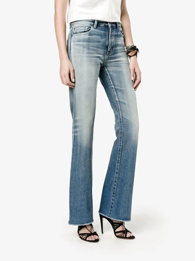 Shop Saint Laurent Raw-cut Flared Jeans In Blue