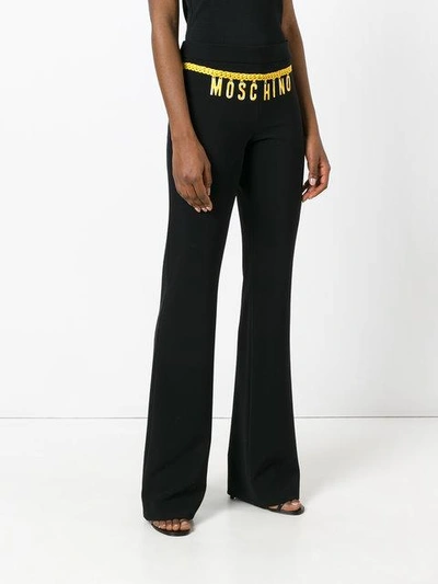 Shop Moschino Printed Logo Chain Trousers In Black