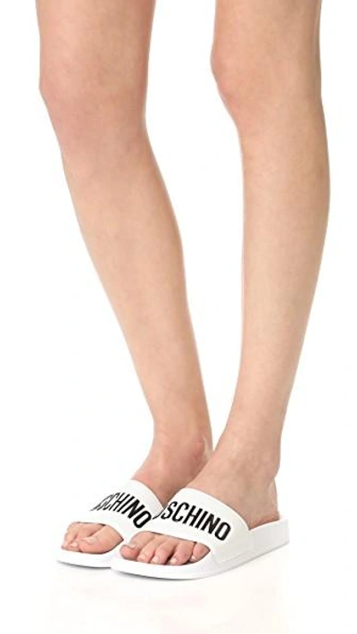 Moschino Embossed Logo Pool Slides In White/black