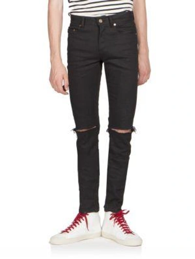 Shop Saint Laurent Ripped-knee Jeans In Black