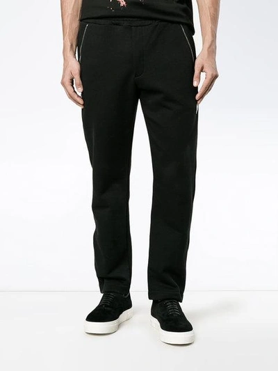 Shop Alexander Mcqueen Zip Detailed Skull Patch Tapered Trousers In Black