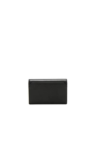 Shop Saint Laurent Large Fragments Flap Wallet In Black. In Black & Black