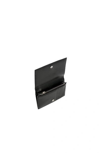 Shop Saint Laurent Large Fragments Flap Wallet In Black. In Black & Black