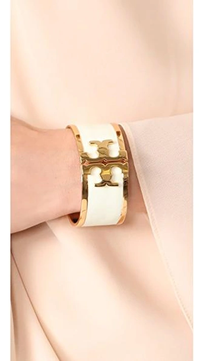 Shop Tory Burch Enamel Raised Logo Wide Cuff Bracelet In New Ivory/tory Gold