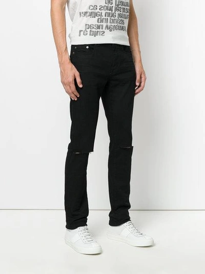 Shop Saint Laurent Busted Knee Slim Fit Jeans - Black