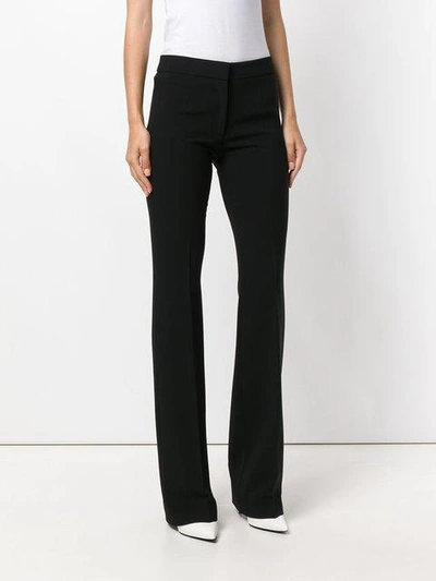 Shop Moschino Flared Trousers In Black