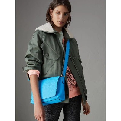 Shop Burberry Small Embossed Neon Leather Messenger Bag In Neon Blue