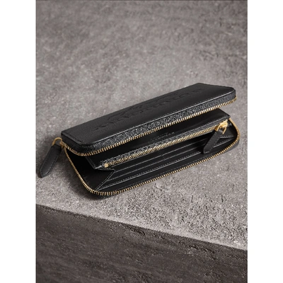 Shop Burberry Embossed Leather Ziparound Wallet In Black