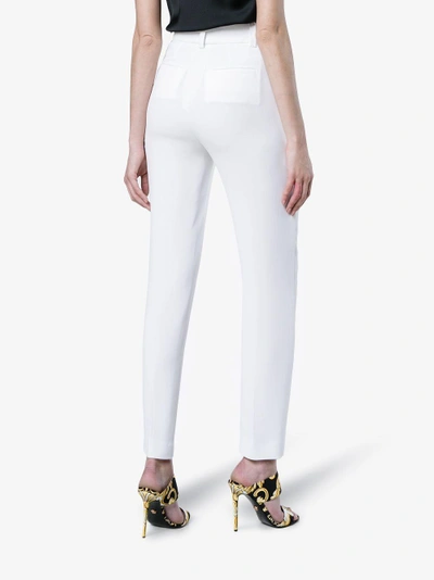 Shop Versace Mid Rise Slim Leg Trousers In White