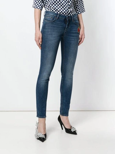 skinny jeans with Sacred Heart patch