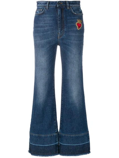 flared jeans with sacred heart appliqué