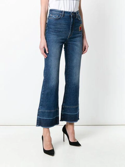 flared jeans with sacred heart appliqué