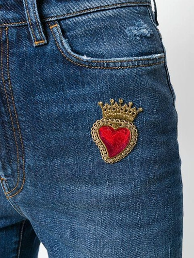 flared jeans with sacred heart appliqué