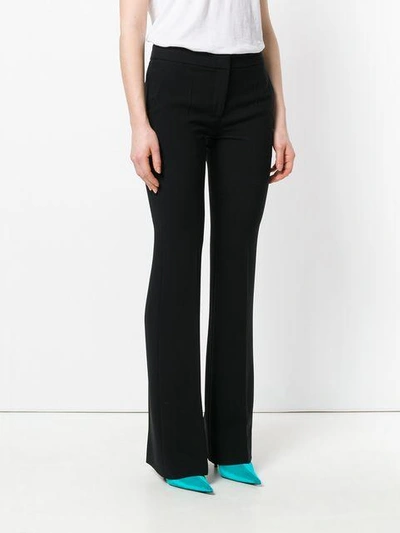 Shop Moschino High Waisted Flared Trousers In Black