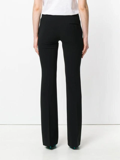 Shop Moschino High Waisted Flared Trousers In Black
