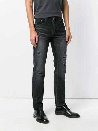 Shop Saint Laurent Ripped Low-rise Skinny Jeans In Black