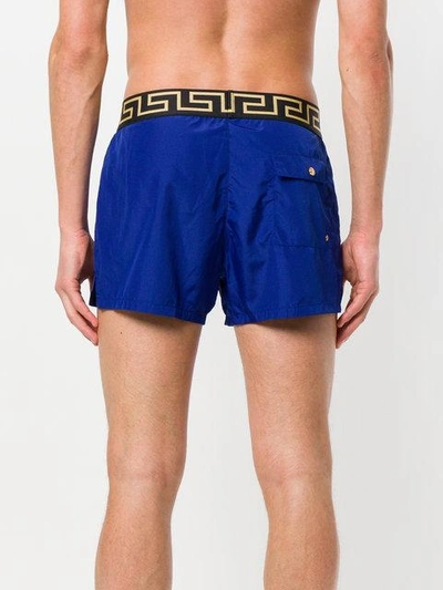 Shop Versace Grecca Waistband Swim Shorts In Blue