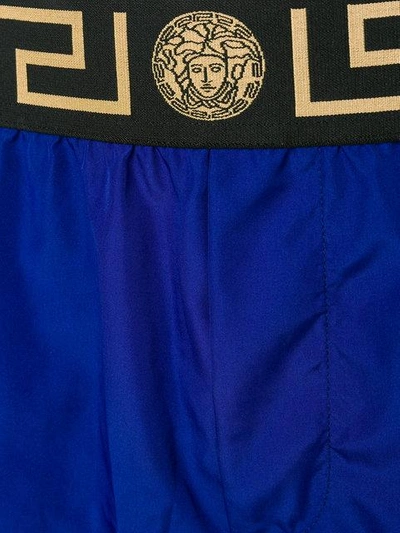 Shop Versace Grecca Waistband Swim Shorts In Blue